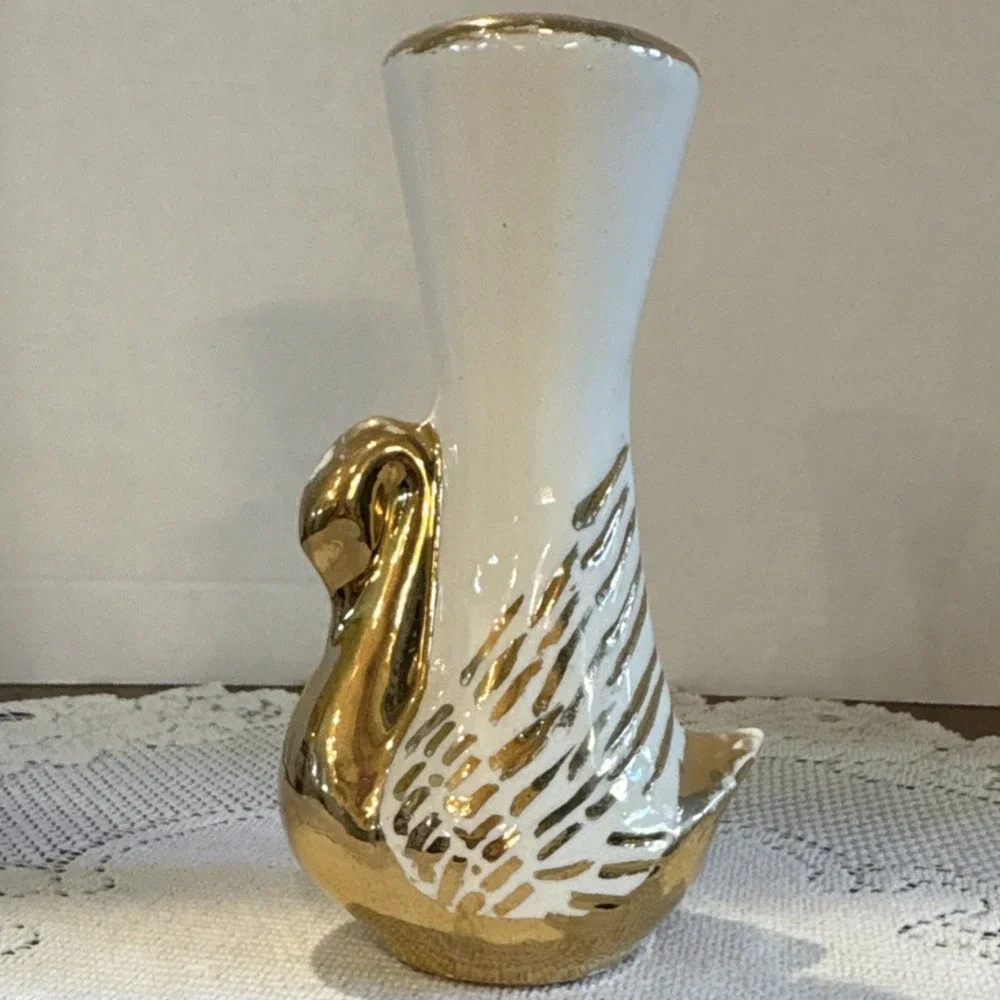 Mid-century modern white ceramic swan bud vase featuring gold leaf accents.